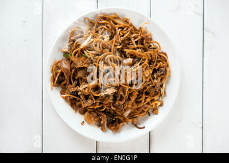 Asiatische Schale gebratenes Char Kuey Teow über hölzerne Hintergrund.  Frisch gekocht mit heißen dämpfen. Stockfoto