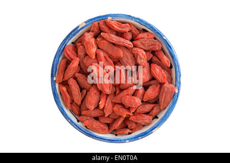 viele getrocknete Goji-Beeren in kleinen blauen Tasse isoliert auf weiss Stockfoto