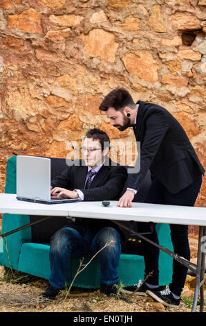 Zwei Jungs um einen Schreibtisch in einem Grunge-Büro, ein Konkurs-Konzept Stockfoto