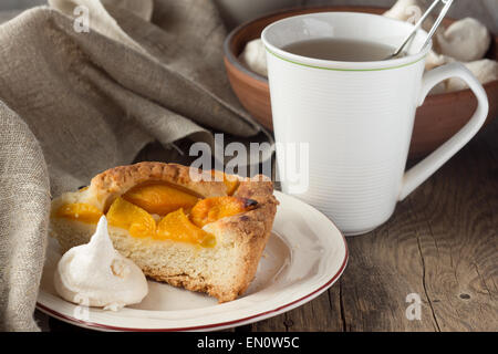 Mürbeteig Pfirsich Torte, Baiser und Tasse Tee selektiven Fokus horizontal Stockfoto