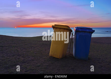 zwei Papierkörbe am Strand bei Sonnenuntergang Stockfoto