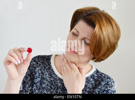 Erwachsene Frau mit einer Halsentzündung auf hellem Hintergrund Stockfoto