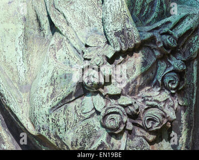 Womans Hand hält einen geschnitzten Kranz von Blumen auf ein Grab in Pere Lachaise Friedhof Paris Frankreich Europa Stockfoto