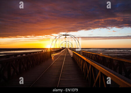 Southport, Merseyside, England 25. April 2015 UK Wetter. Farbenfrohen Sonnenuntergang über Southport Attraktionen. Zu dieser Zeit des Jahres richtet sich die untergehende Sonne direkt entlang der Länge des Piers, ein lokaler saisonale Stonehenge Art auftreten, mit dem Jahrgang viktorianischen Pier, die scheinbar bis zum Horizont erstrecken, wie die Sonne über die irische See. Bildnachweis: Mar Photographics/Alamy Live-Nachrichten Stockfoto