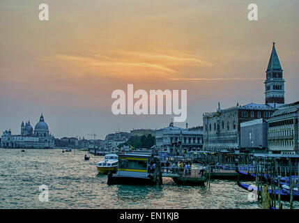 7. Oktober 2004 - Venedig, Provinz Venedig, Italien - ist der Himmel mit dem Schein des Sonnenuntergangs über der Küste von Venedig gestreift. Auf der linken Seite, in Ferne stehen die Kuppeln der Basilika Santa Maria della Salute auf den schmalen Finger der Punta della Dogana, zwischen Canal Grande und dem Canale della Giudecca. Im Zentrum ist die S.Zaccaria Vaporetto dock.on die Becken von St. Markus (Bacino di San Marco). Auf der rechten Seite dockt die Gondel Linie der Riva Degli Schiavoni Uferpromenade vor dem Palazzo Ducale (Dogenpalast) mit der Spitze des Campanile di San Marco (Glockenturm) erhebt sich über sie. Venedig ist eines der am meisten pop Stockfoto