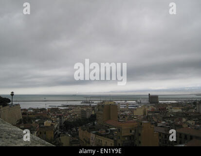 Von Cagliari Skyline mit Gebäuden, Hafen, Meer und düsteren grauen bewölktem Himmel in Sardinien Stockfoto