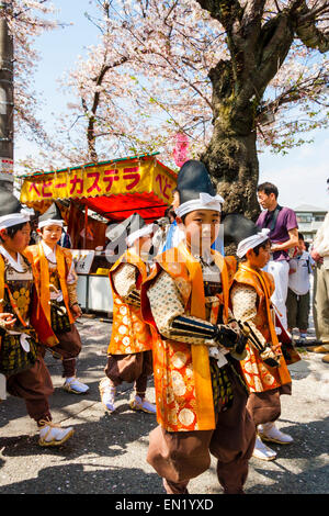 Team von Kindern, Jungen, marschieren verkleidet als Heian-Ära Soldaten in der Frühling Genji Parade unter den Kirschblüten in Tada, Japan. Stockfoto