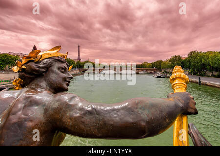 Blick auf Seine und Eiffelturm im Hintergrund unter bewölktem Himmel von Alexander III-Brücke in Paris, Frankreich. Stockfoto