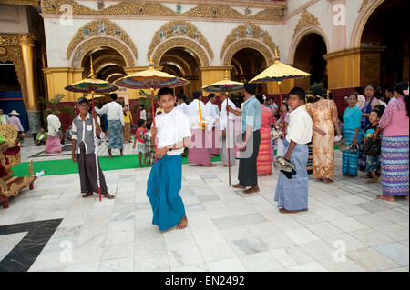 Burmesische Mann hält einen zeremonielle Sonnenschirm macht ein Gesicht in die Kamera Zeremonie Mandalay Myanmar Stockfoto