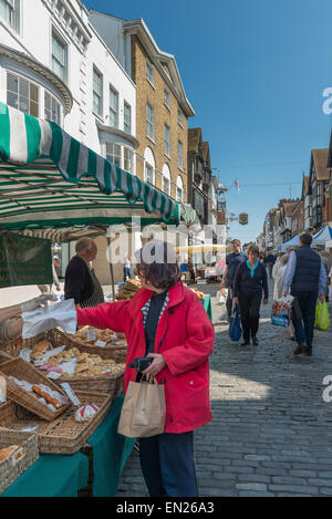 Regelmäßige monatliche Bauernmarkt auf der gepflasterten Guildford High Street mit einem Verkauf von Brot und Kuchen im Vordergrund stand Stockfoto