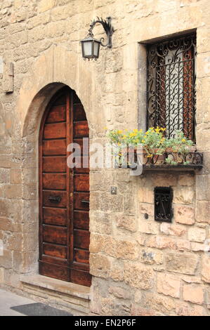 Mittelalterliche Tür mit Lampe, Fenster und Blumentöpfe Stockfoto