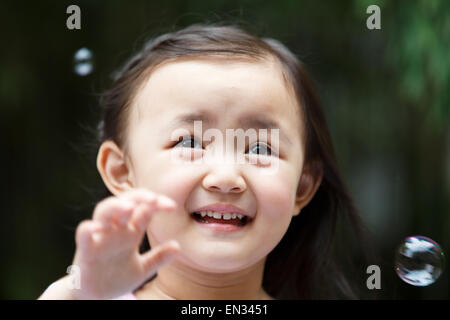 Niedliche kleine Mädchen draußen spielen Stockfoto