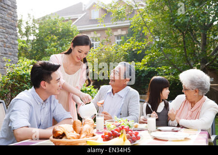 Glückliche Familien frühstücken im freien Stockfoto