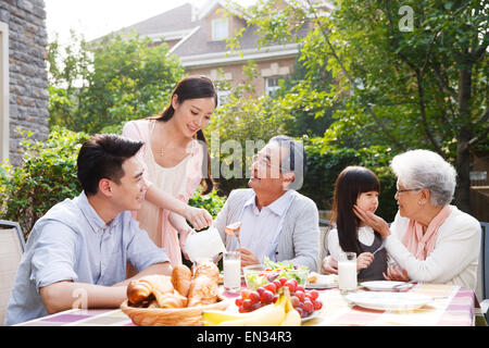 Glückliche Familien frühstücken im freien Stockfoto