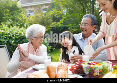 Glückliche Familien frühstücken im freien Stockfoto