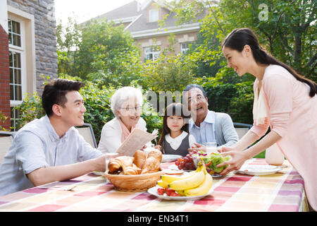 Glückliche Familien frühstücken im freien Stockfoto