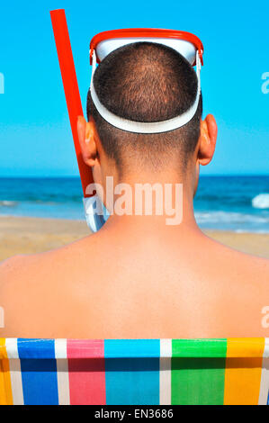 Blick auf die Rückseite eines Mannes trägt eine Taucherbrille und einen Schnorchel am Strand Stockfoto