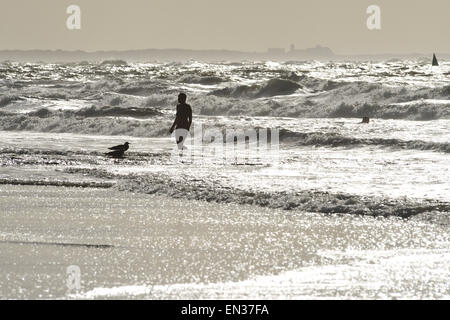 Frau vor der Brandung der Nordsee im Gegenlicht, Norderney, Ostfriesland, Niedersachsen, Deutschland Stockfoto