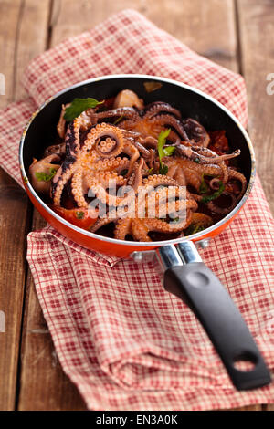 Italienisches Essen. Baby-Tintenfische mit Tomaten, Knoblauch und Petersilie zubereitet. Stockfoto