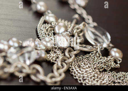 Verschiedene Silber Modeschmuck mit einem Durcheinander Haufen Ketten mit verschiedenen geformten Links, einem klaren Kristallperle und eine Halskette Stockfoto