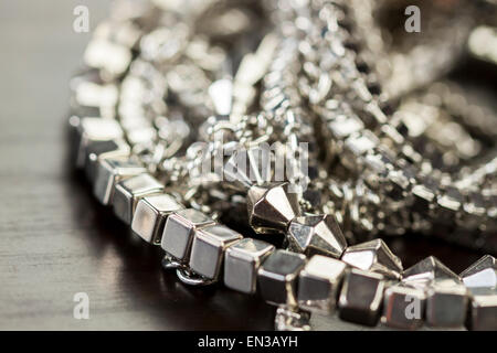 Verschiedene Silber Modeschmuck mit einem Durcheinander Haufen Ketten mit verschiedenen geformten Links, einem klaren Kristallperle und eine Halskette Stockfoto