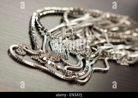 Verschiedene Silber Modeschmuck mit einem Durcheinander Haufen Ketten mit verschiedenen geformten Links, einem klaren Kristallperle und eine Halskette Stockfoto
