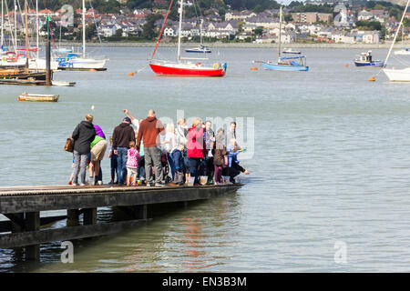 Familien für Krebse angeln off eine Slipanlage an der Mündung des Flusses Conwy, Wales. Stockfoto