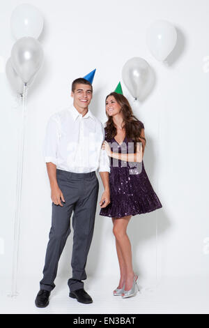 Junges Paar lächelnd unter Ballons auf party Stockfoto