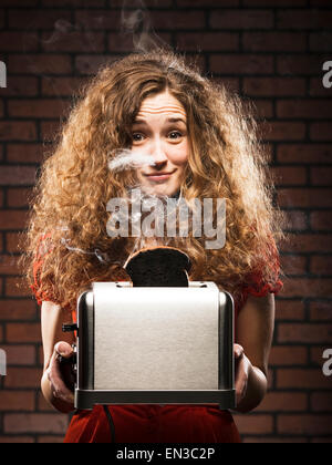 Frau, die immer von einem Toaster Stromschlag Stockfoto