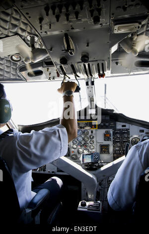 Rückansicht eines Piloten die Systemsteuerung in einem Flugzeug in Betrieb Stockfoto