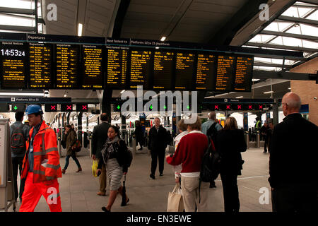 Zugfahrt. Leute, die am Abfahrtsschild des Bahnhofs Waterloo, London, England schauen. Stockfoto