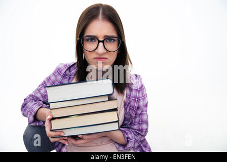 Unglückliche junge Studentin mit Bücher über weißem Hintergrund. Blick in die Kamera Stockfoto