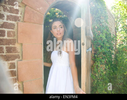 USA, Utah, Lehi, Porträt von Teenager-Mädchen (16-17) spähen hinter Tür Stockfoto