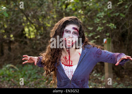 Junge Frau in Zombie Make-up macht drohende Geste in die Kamera Stockfoto