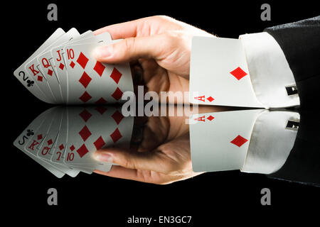 Spielkarten mit einem Ass im Ärmel halten die Hand Stockfoto