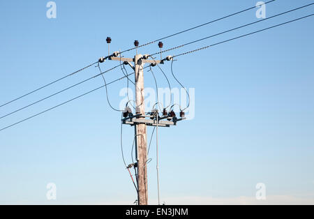 Nahaufnahme von Stromkabeln und Telegrafenmast gegen blauen Himmel, UK Stockfoto