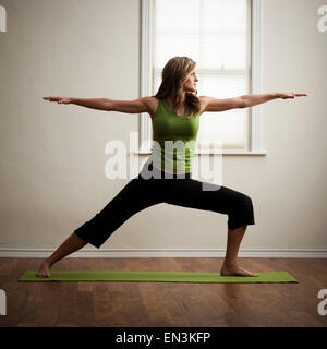 USA, Utah, Orem, junge Frau, die Durchführung von Yoga im Innenbereich Stockfoto