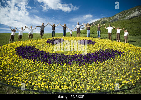 Großen Familiengruppe auf Hügel mit floralen glückliches Gesicht anzeigen Stockfoto