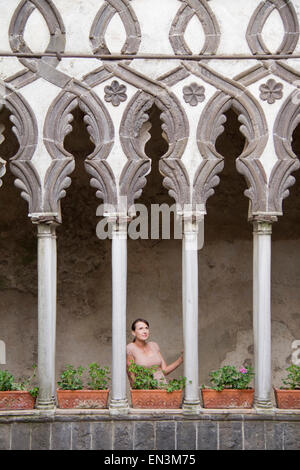 Italien, Ravello, Frau stehend auf Balkon zwischen reich verzierten Säulen Stockfoto