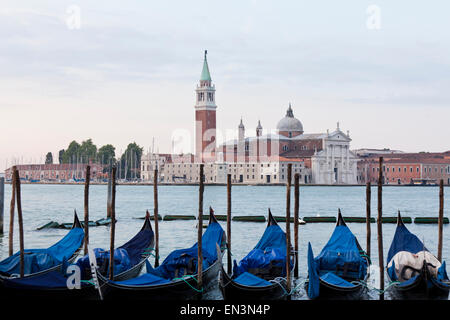 Italien, Venedig, junges Paar umarmt von Lagune, die Gondeln und die Kirche San Giorgio Maggiore im Hintergrund Stockfoto