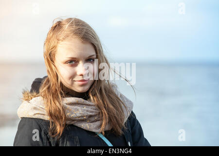 Nahaufnahme Outdoor-Porträt von lächelnden schönen blonden kaukasischen Teenager-Mädchen an einer Küste Stockfoto