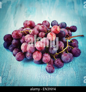 Reihe von blauen Traube auf blauem Hintergrund rustikal. Selektiven Fokus. Instagram-Vintage-Effekt. Korn für besten Eindruck hinzugefügt. Stockfoto