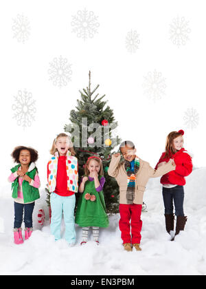 Gruppe von Kindern (18-23months, 4-5,6-7) stehen neben Weihnachtsbaum Stockfoto