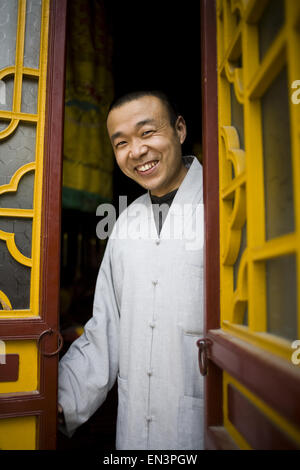 Mann, der in reich verzierte Tür in Asien lächelnd Stockfoto