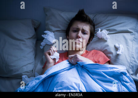 Frau im Bett mit Gewebe Stockfoto