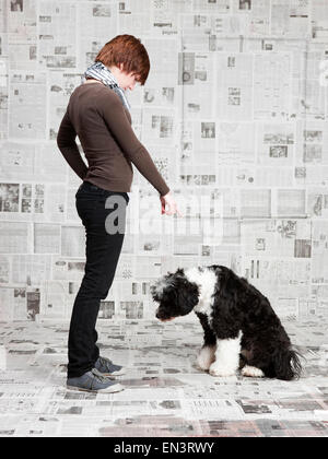 Junge Frau schelten ihr Portugiesischer Wasserhund Stockfoto