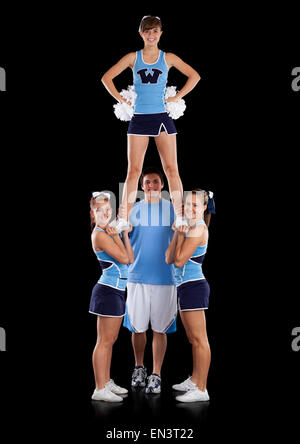 Studio shot der Cheerleader (16-17) Unterstützung Freund während der Leistung Stockfoto