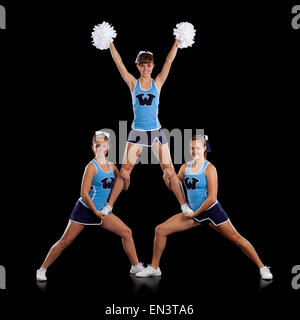 Studio shot der Cheerleader (16-17) Unterstützung Freund während der Leistung Stockfoto