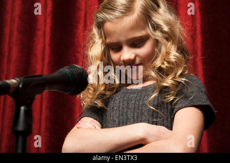 Porträt eines Mädchens (8-9) mit Armen, Orem, Utah, USA gekreuzt vor Mikrofon Stockfoto