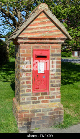 Royal Mail rote Briefkasten in einer Ziegelsteinsäule, in England, Großbritannien. Stockfoto